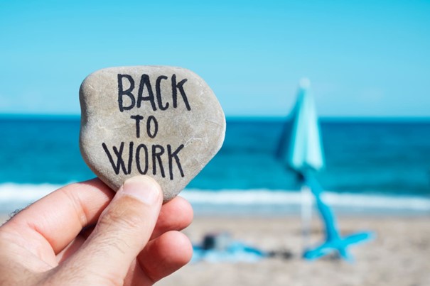Galet « Back to work » tenu devant la plage