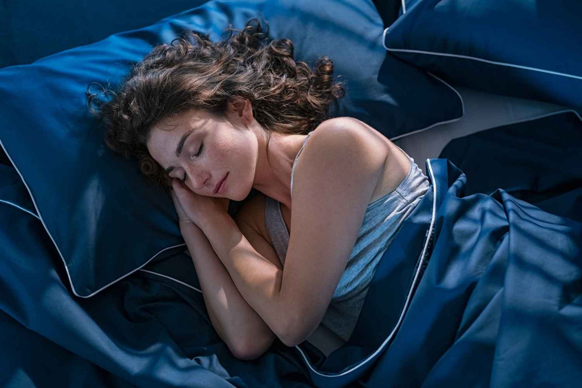 Femme endormie dans des draps bleus