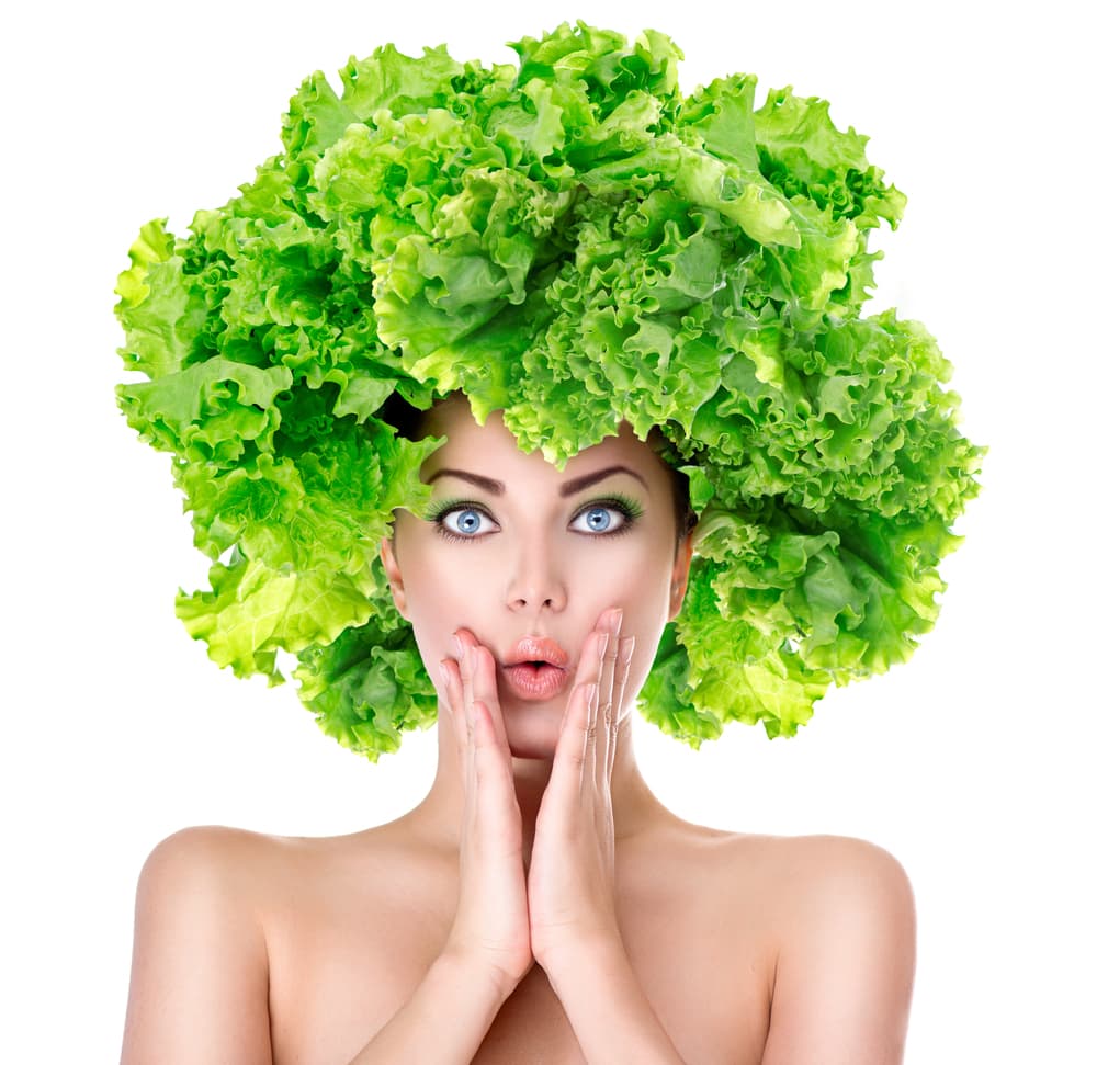 Femme coiffée d'une salade verte, l'air étonné
