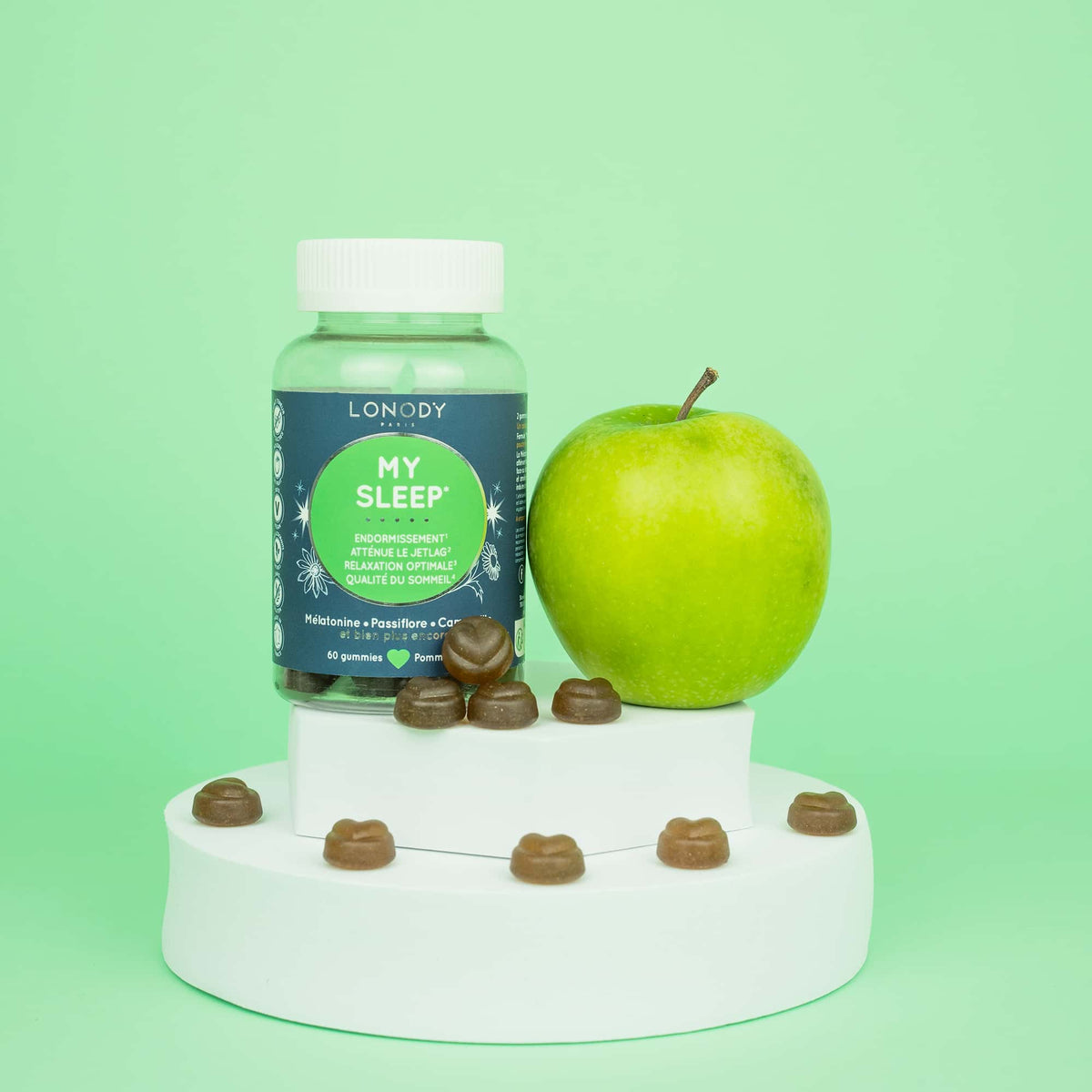 Flacon My Sleep de Lonody avec ses gummies et une pomme verte sur fond vert